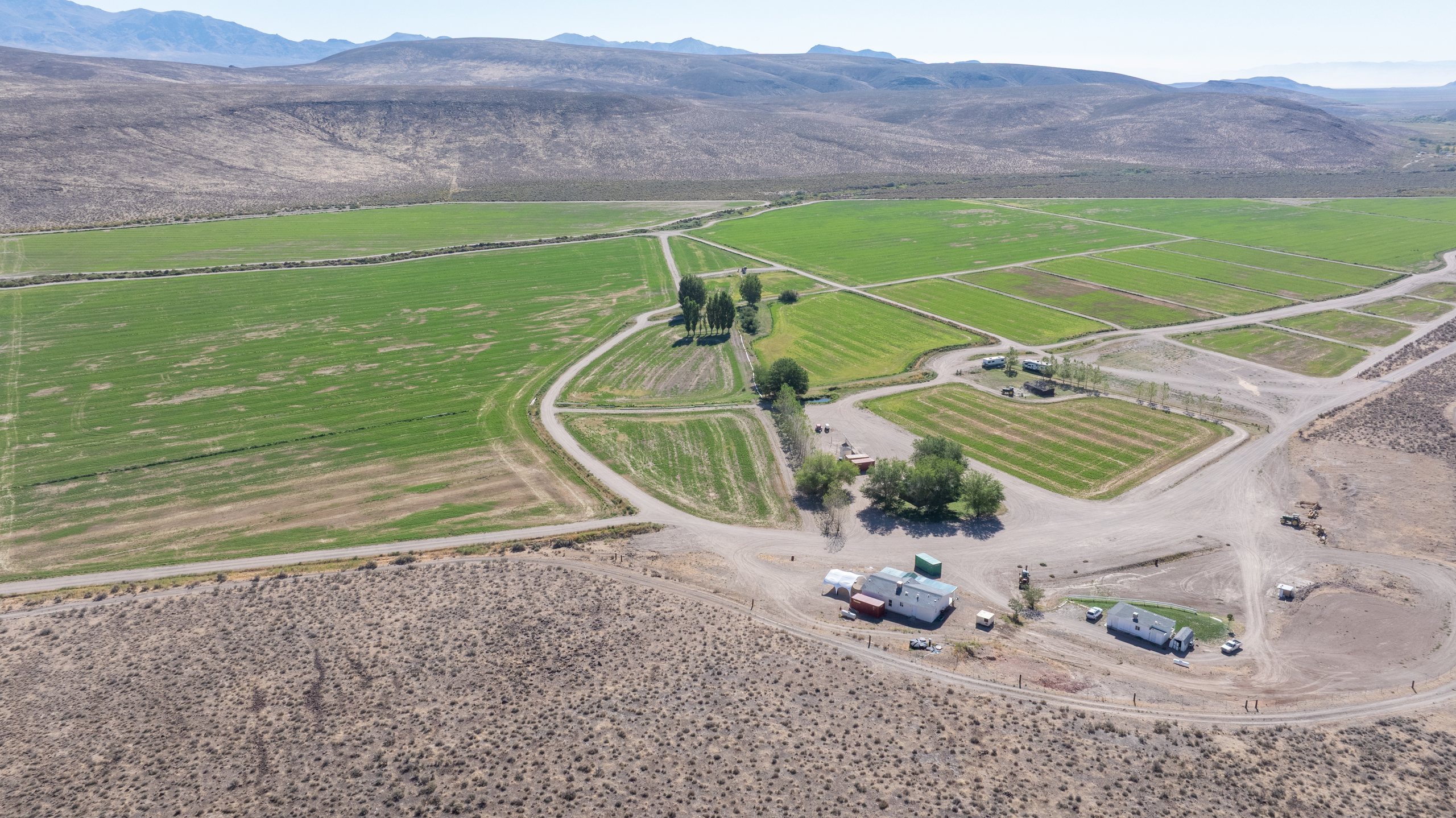 Wide aerial of a working farm, its buildings, and the surrounding hills, northern Washoe County, Nevada